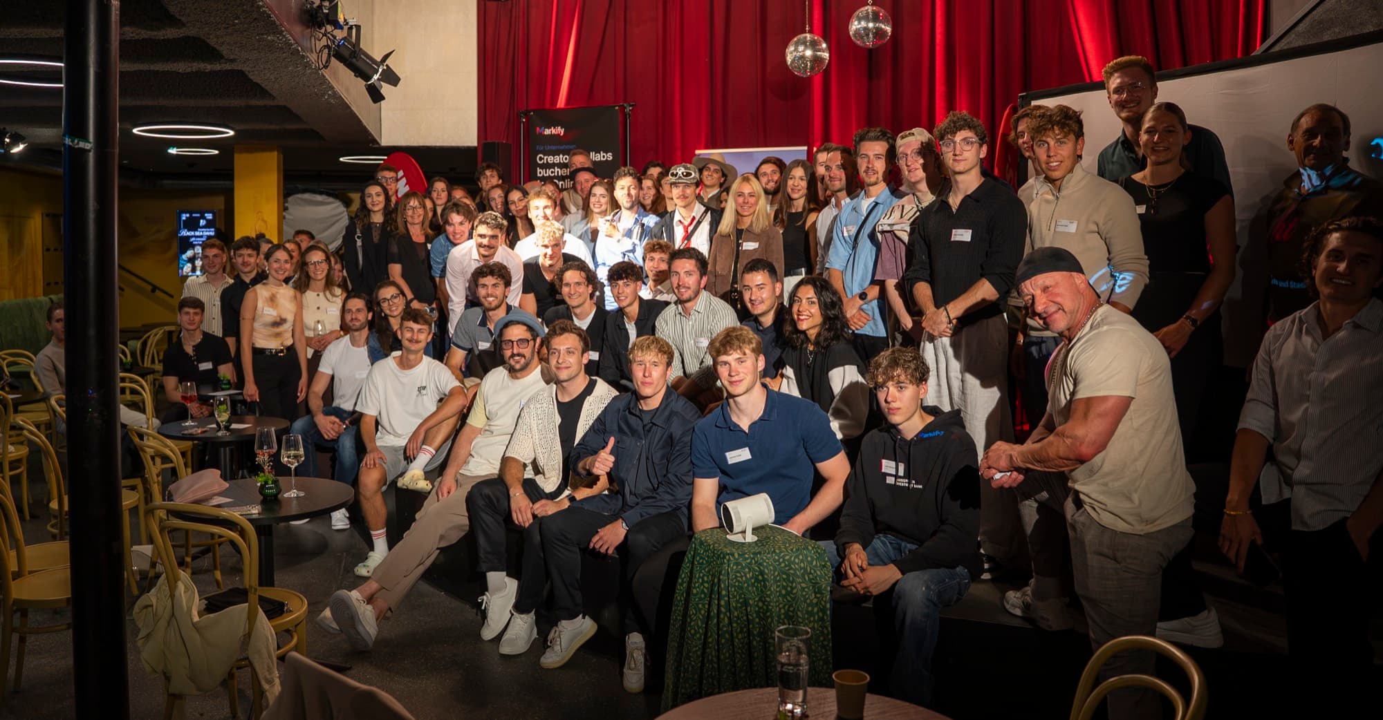 Gruppenbild mit einem Teil der Gäste der ersten Creator Night im mariatheresia, vor rotem Vorhang
